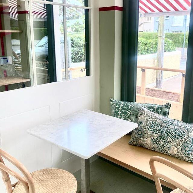 A window seat with a marble table and green patterned cushions